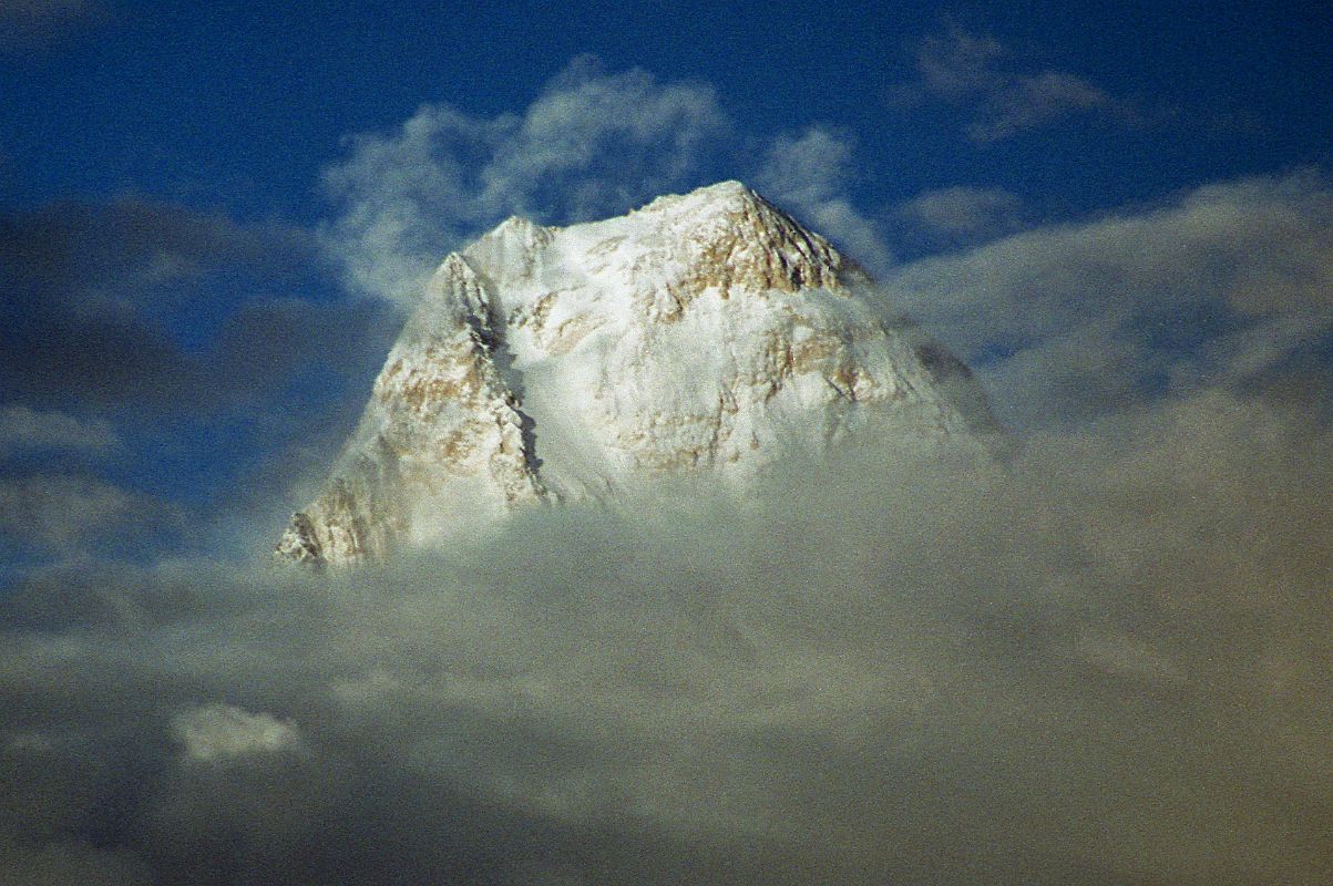 14 Gasherbrum IV Summit Peaks Out Of Clouds At Sunset From Goro II The West Face of Gasherbrum IV shines at sunset from Goro II. The first ascent of Gasherbrum IV was made via the northeast ridge on August 6, 1958 by famed Italian mountaineer Walter Bonatti and Carlo Mauri on a strong Italian team led by legendary climber Riccardo Cassin. �A desperate struggle between the mountain and ourselves, but we were all winners, and at 12.30 exactly the little pennants of Italy, Pakistan and the C.A.I. fluttered on the Summit itself. Fluttered � no, blew out in the howling gale.� - Karakoram: The Ascent Of Gasherbrum IV by Fosco Maraini.